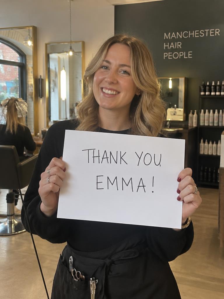 Salon stylist holding a personalised thank-you sign